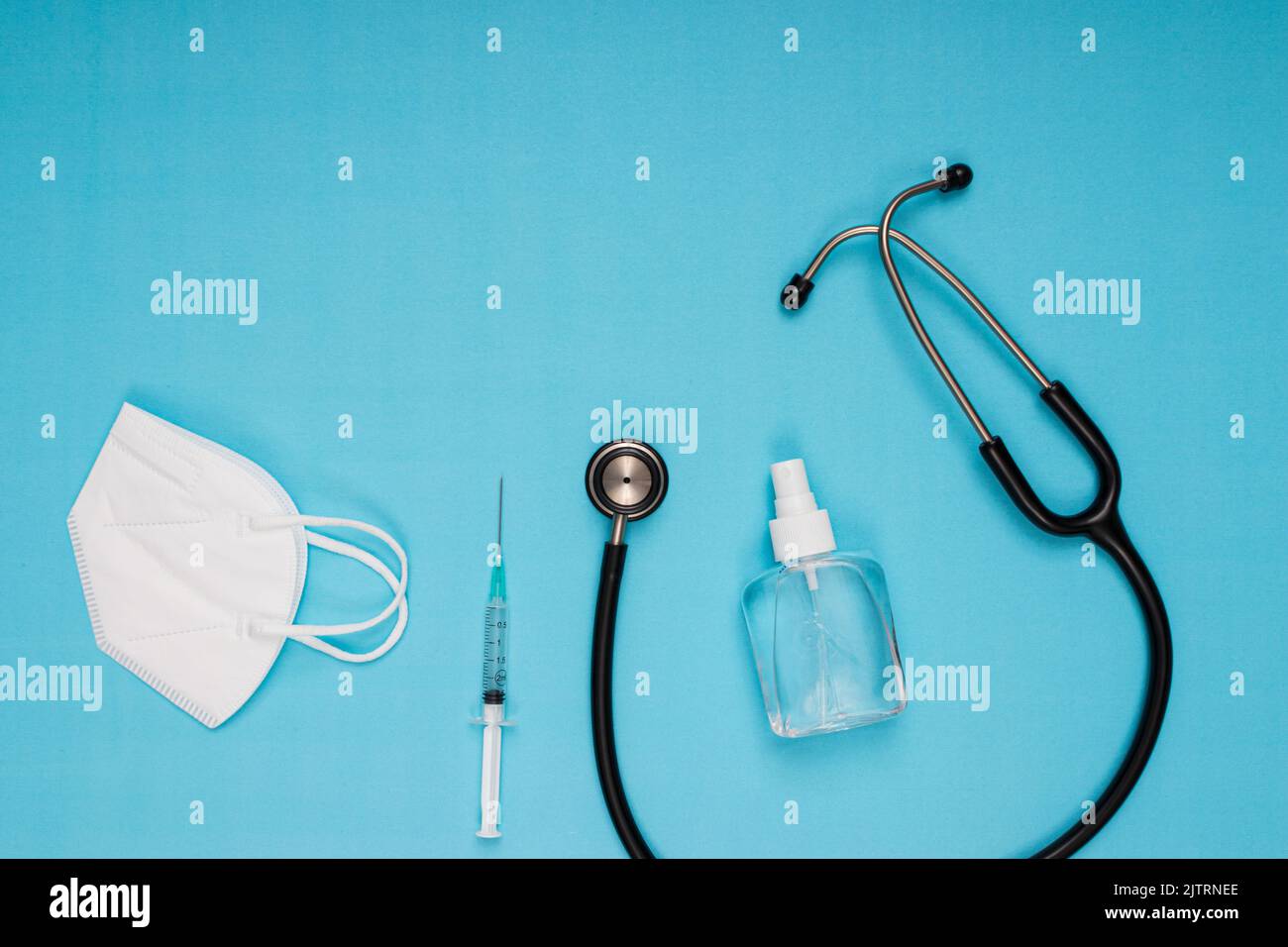 stethoscope, disinfectant, needle, vaccine, mask standing on blue