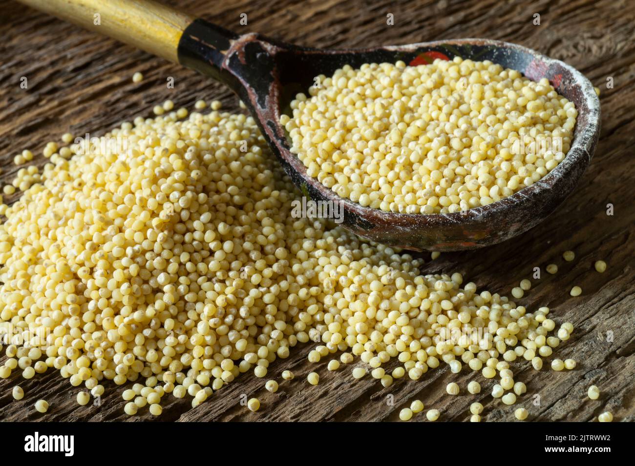 Still life with food on an old board. Round grain grain of yellow color Stock Photo
