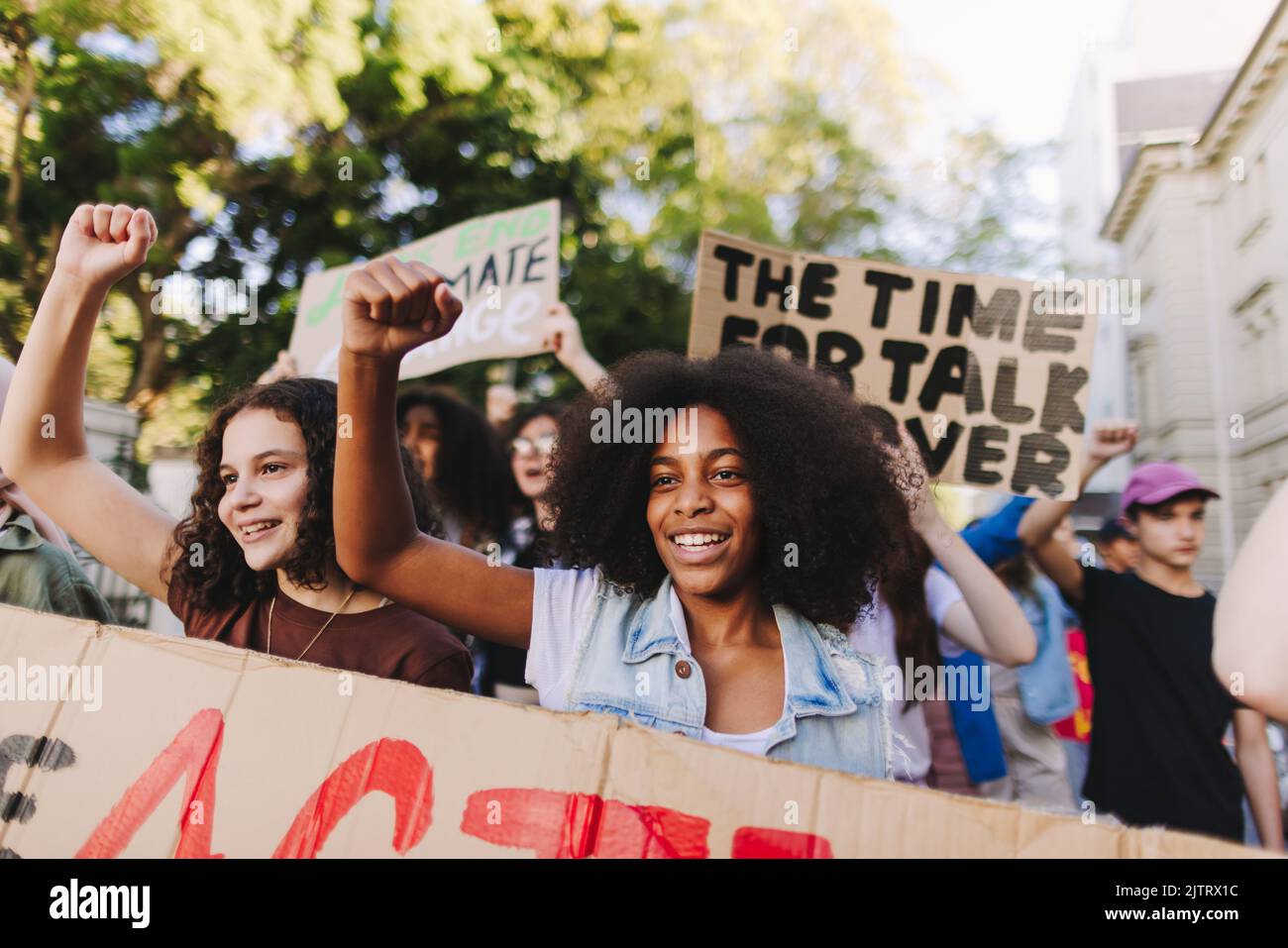 Multiethnic teenagers taking action against climate change. Group of youth activists protesting against global warming and pollution. Diverse young pe Stock Photo