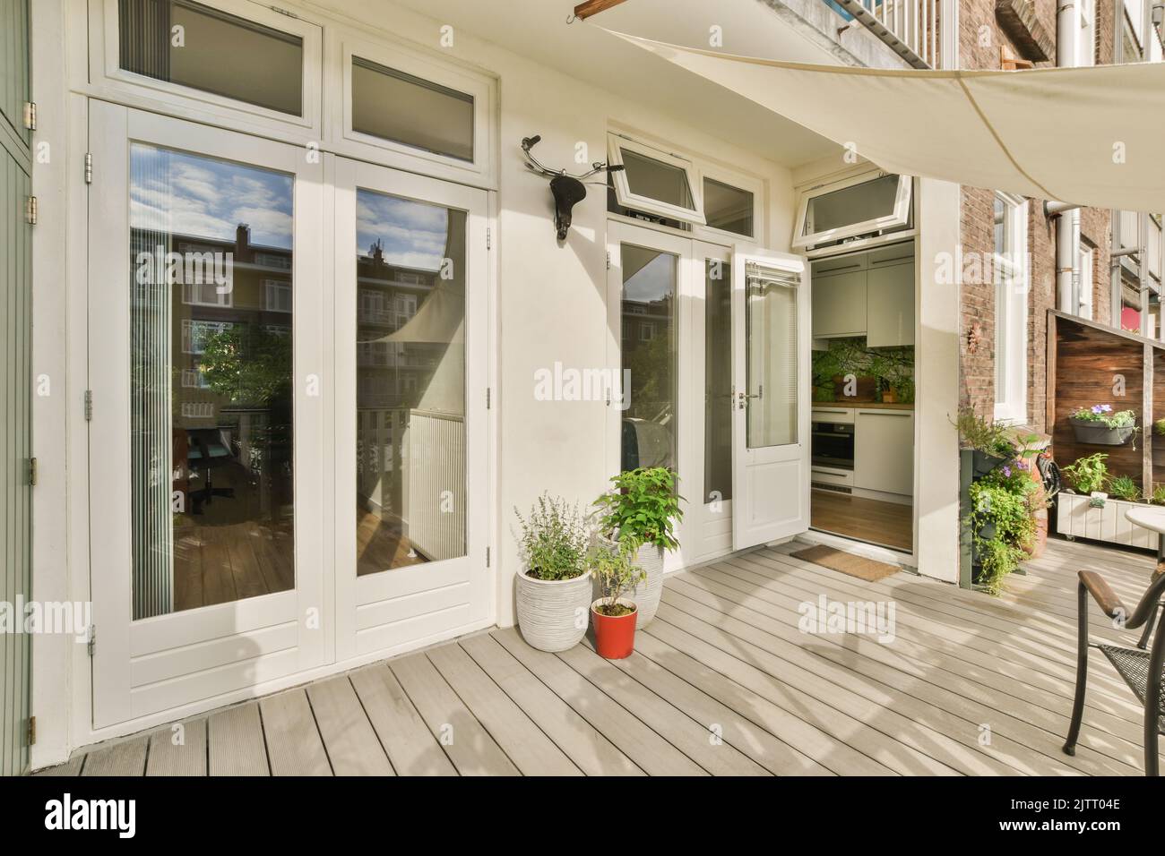 spacious balcony with metal railings, wooden chair and door with glass