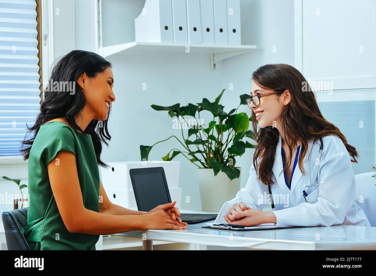 Female doctor and patient smiling consultation clinic health checkup treatment Stock Photo