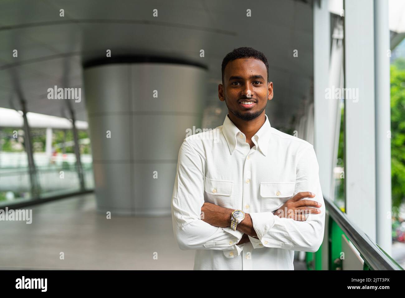 Portrait of young handsome stylish black man enjoying city life Stock Photo