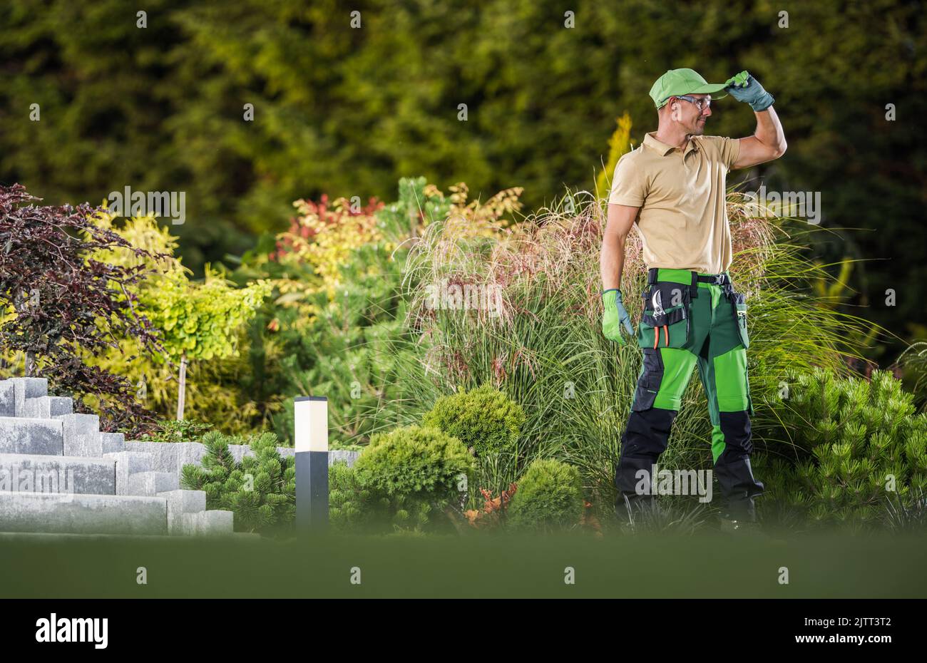 Smiling Caucasian Gardener Proudly Standing in Front of Successfully