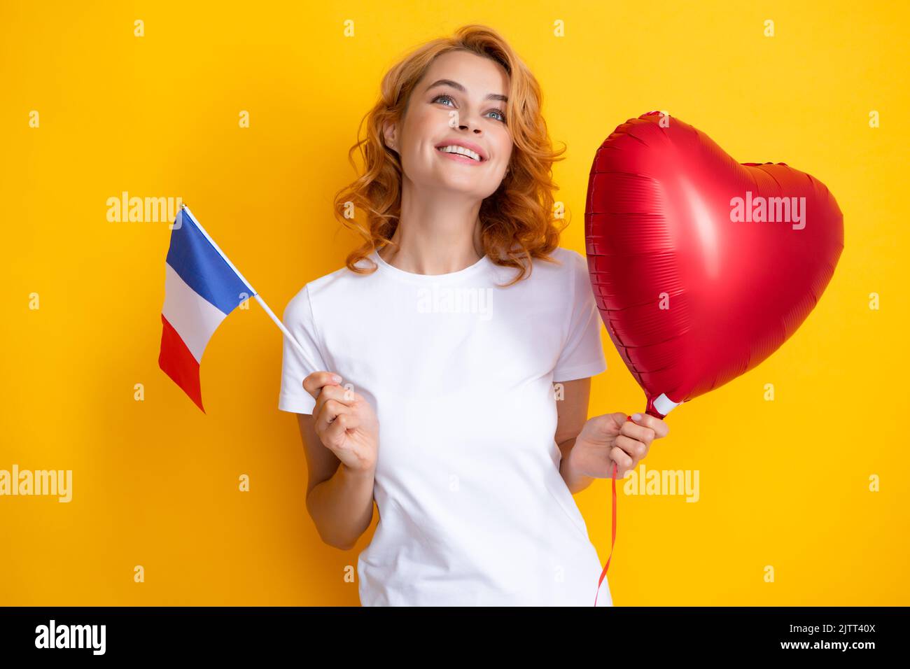 Woman holding flag of France and red heart balloon. Student holding