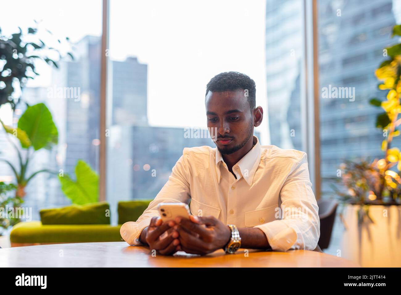 Portrait of young handsome stylish black man enjoying city life Stock Photo