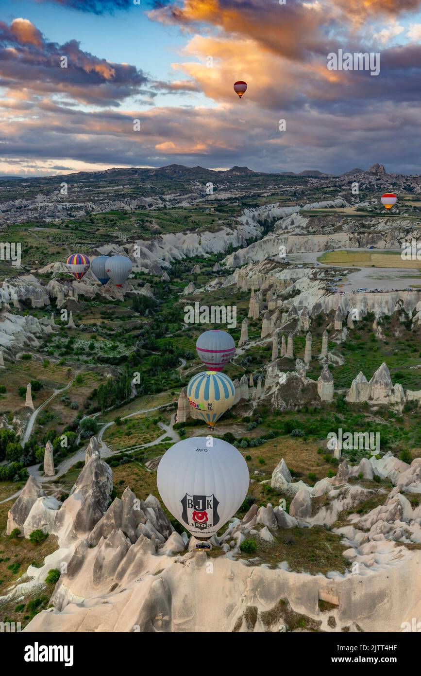 GOREME/TURKEY - June 26, 2022: colorful hot air balloons fly at sunrise near goreme, vie from balloon Stock Photo