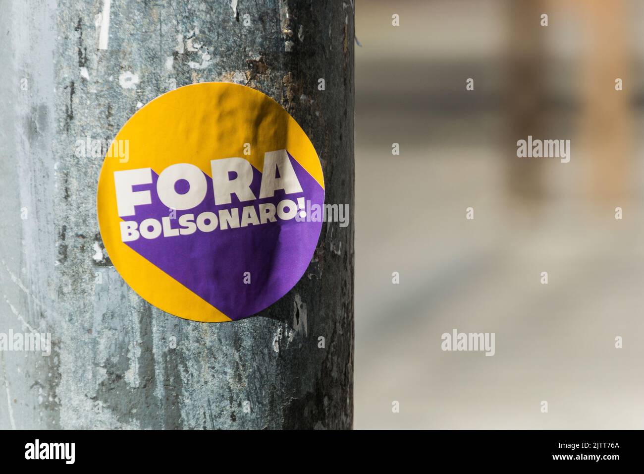 sticker pasted on a post, with the words in brazilian portuguese 