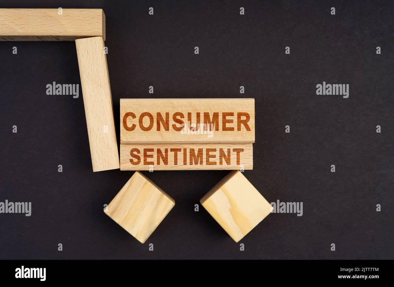 Business concept. On a black surface, a cart made of blocks and cubes with the inscription - Consumer Sentiment Stock Photo
