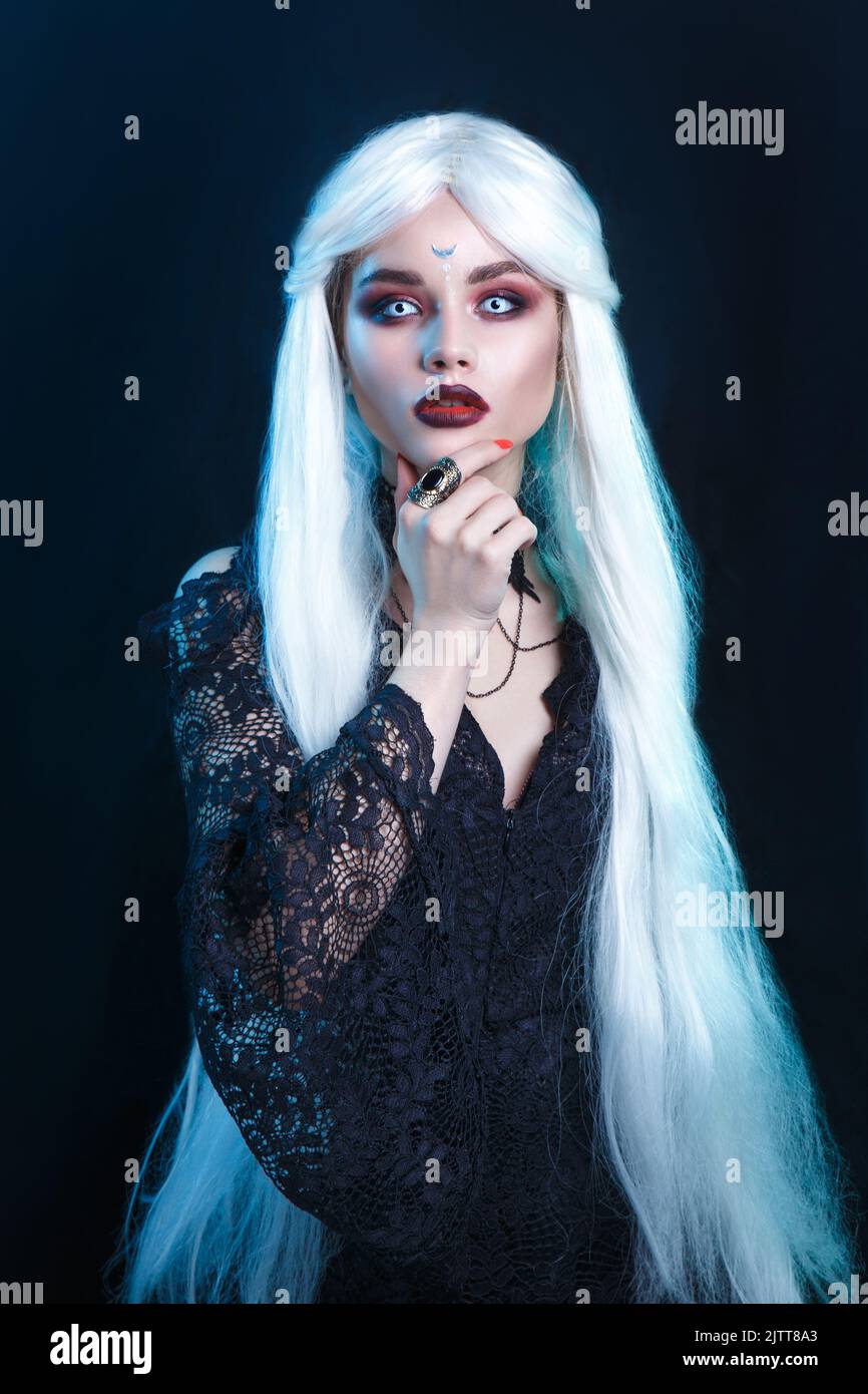 Beautiful sexy Halloween vampire woman portrait on dark magic background Stock Photo