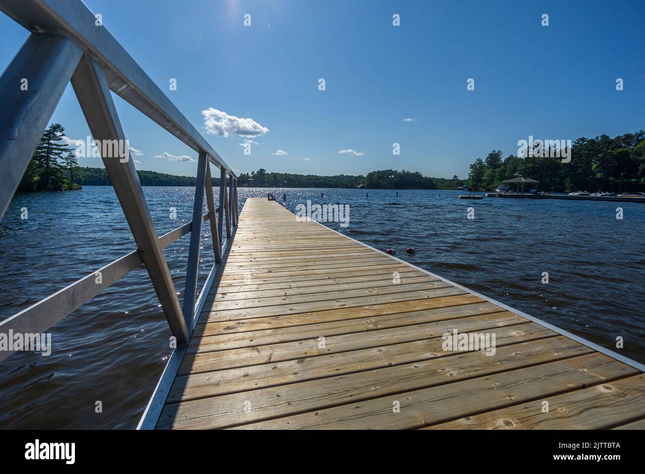 Wooden jetty with metal railing on Lake Rosseau, Muskoka, Ontario, Canada. A popular place for
