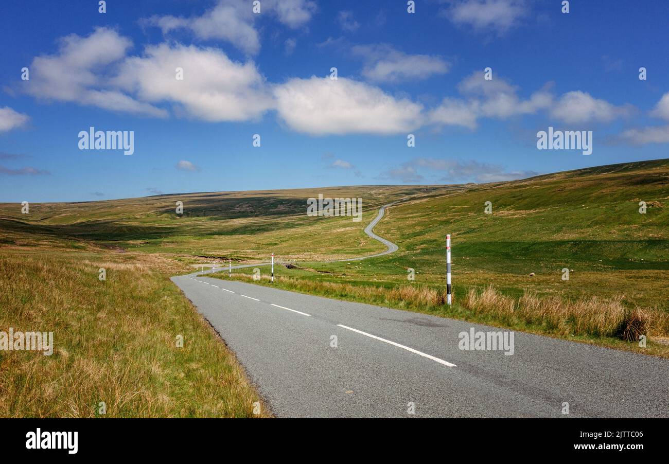 View from Teesdale looking up the road to Chapel Fell mountain pass with a sheep in the foreground, Country Durham, England, UK Stock Photo