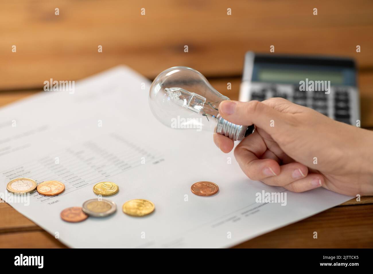 hand with lightbulb, bill, calculator and money Stock Photo