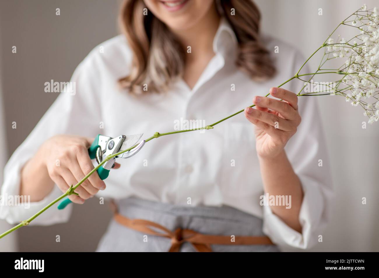 woman cutting flower stem with pruning shears Stock Photo