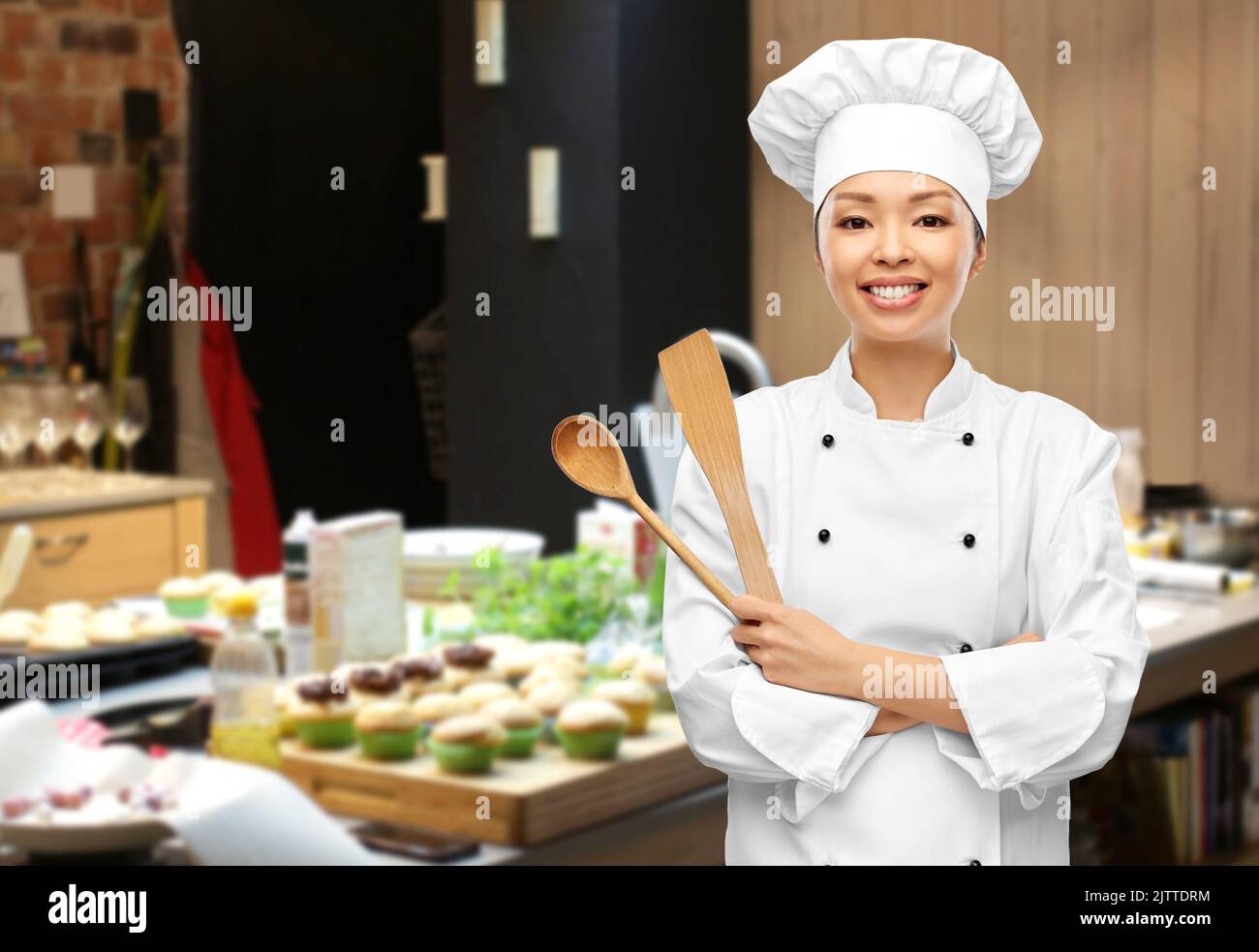 happy smiling female chef with wooden spoon Stock Photo