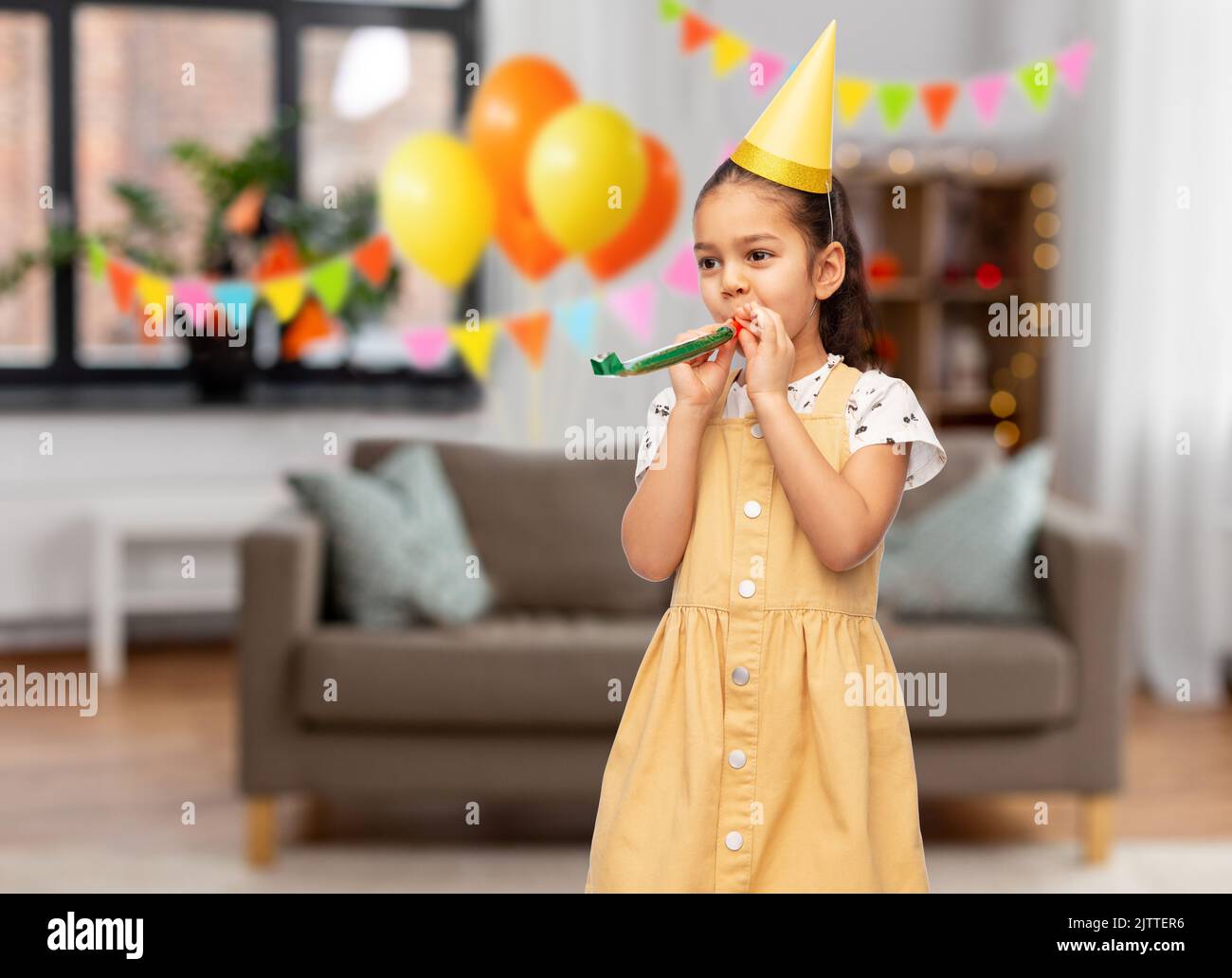 girl with blower at birthday party at home Stock Photo - Alamy