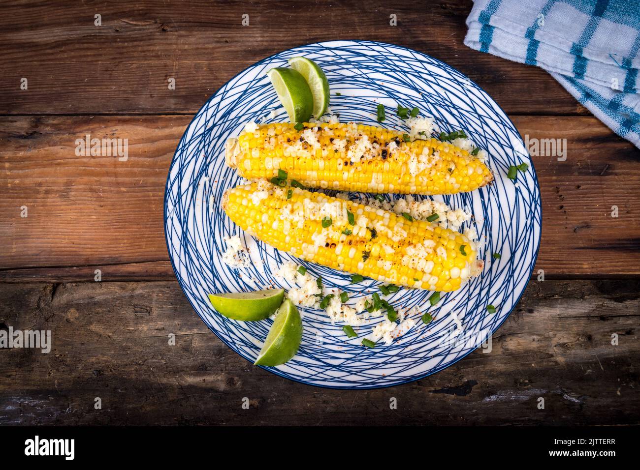 Elote delicious grilled mexican corn with cheese herbs and lime closeup Stock Photo