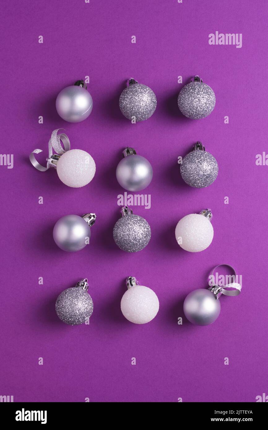 Christmas baubles arranged on purple background. Top view. Stock Photo