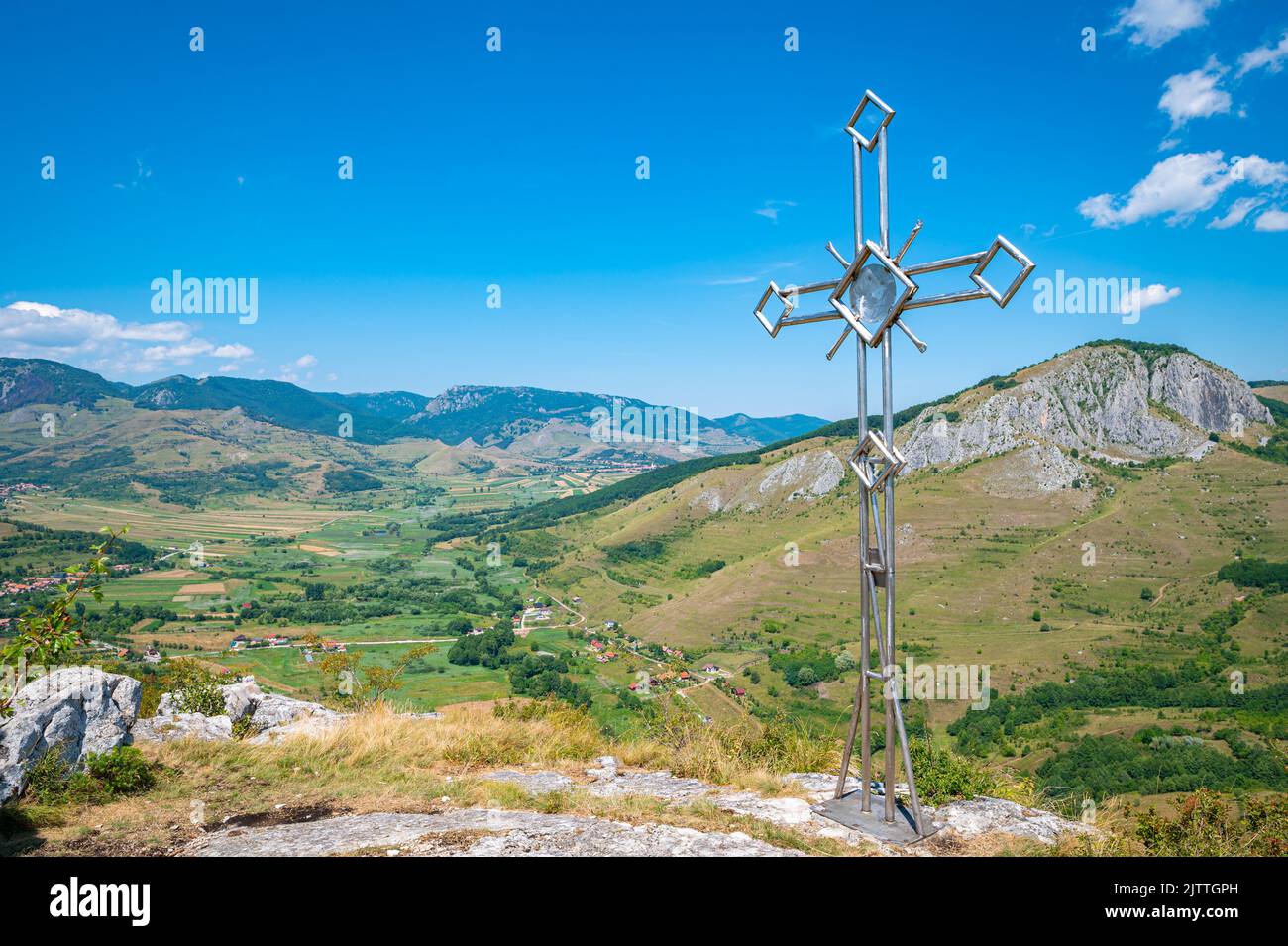 Cross on the top of a mountain with stunning view over the landscape in Apuseni Mountain Range in Transylvania, Romania Stock Photo