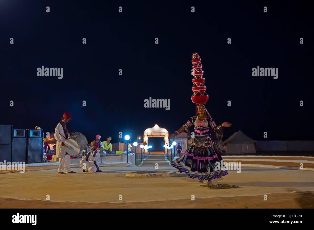 Thar desert, Rajasthan, India - October 15th 2019 : Female dancer dancing Bhavai, a folk dance, balancing six earthen pots on her head riding glasses Stock Photo