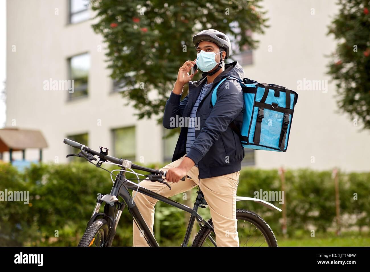 delivery man in mask with smatphone riding bicycle Stock Photo - Alamy