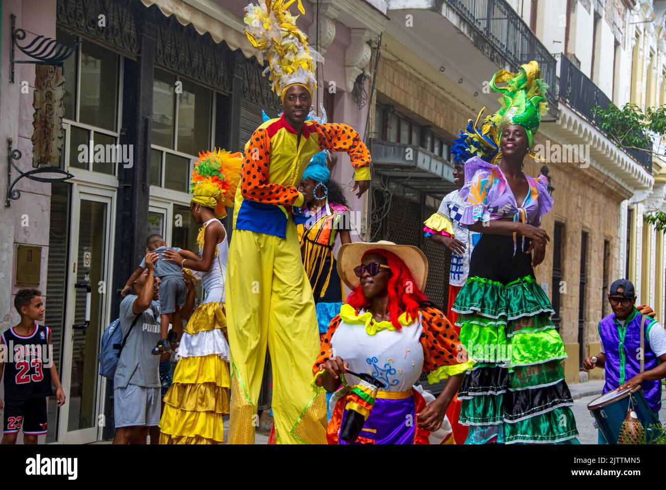A group of Cuban entertainers and musicians stilt walk their way around downtown, Havana, Cuba, performing for both locals and tourists. Stock Photo