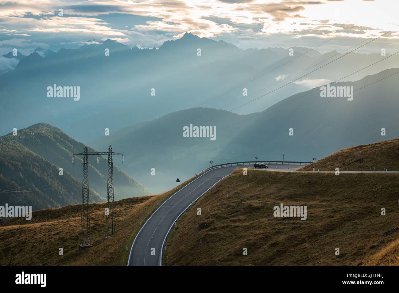 Beautiful sunrise on the Jaufenpass or Passo Giovo in northern italy with beautiful road winding on the mountain and sun just rising over the dolomite Stock Photo