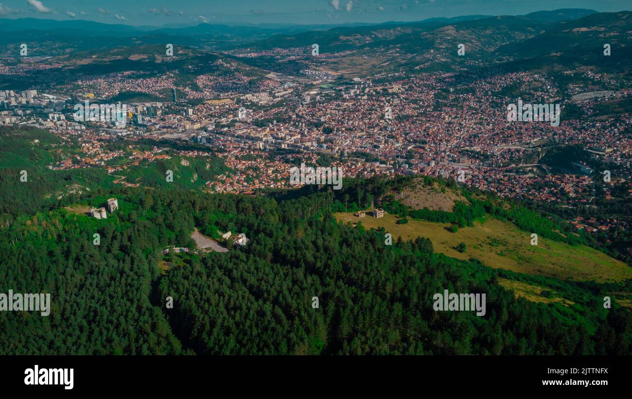 Aerial drone panorama of the city of Sarajevo on a summer day. Viewed from a vantage point close to upper station of gondola or cable car. Stock Photo