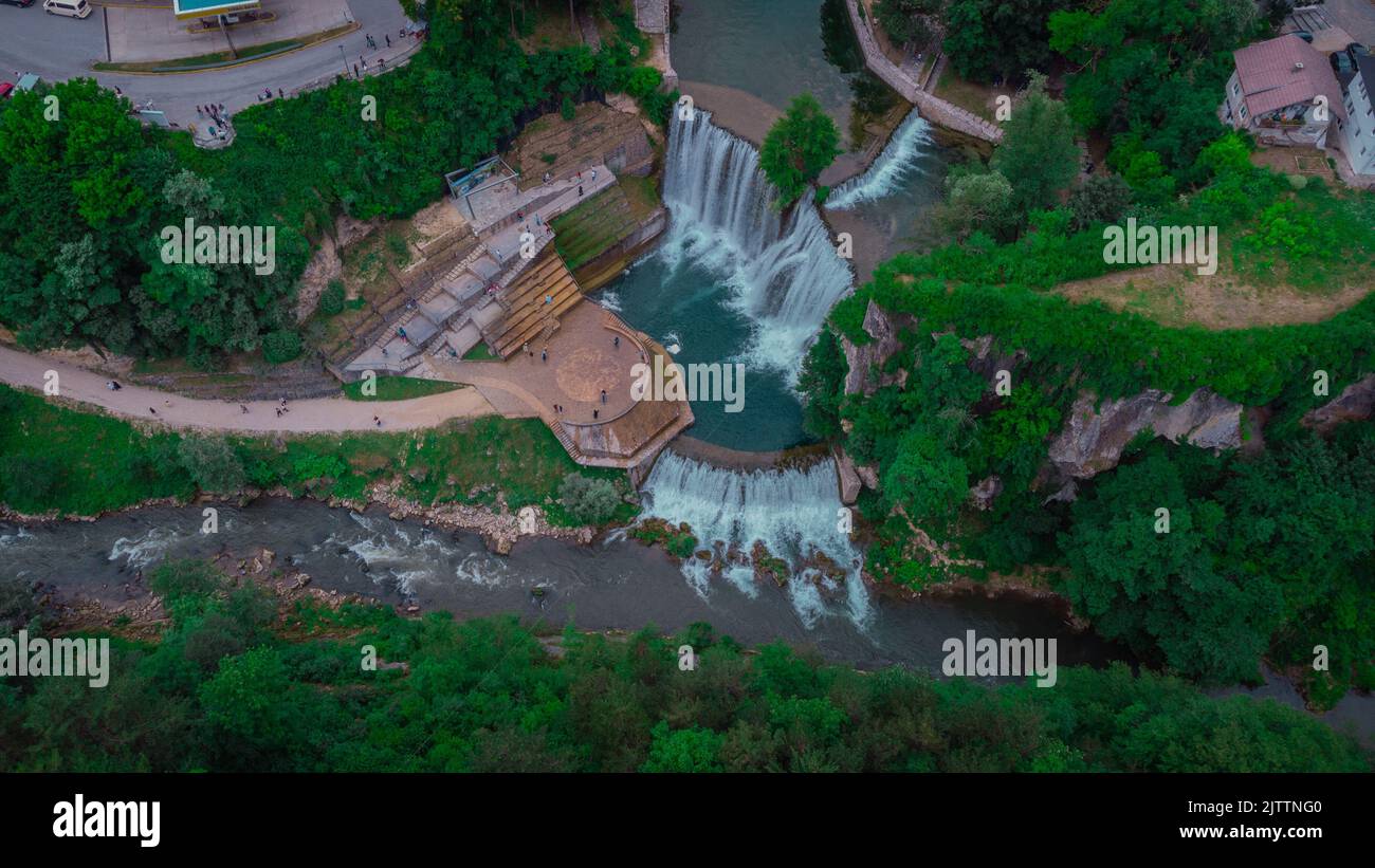 Aerial drone panorama of Pliva river waterfalls at Jajce, bosnia and hercegovina. Spectators looking at the waterfalls on a cloudy day. Stock Photo