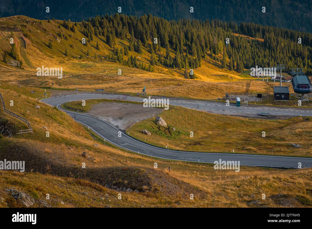 Beautiful sunrise on the Jaufenpass or Passo Giovo in northern italy with beautiful road winding on the mountain and sun just rising over the dolomite Stock Photo