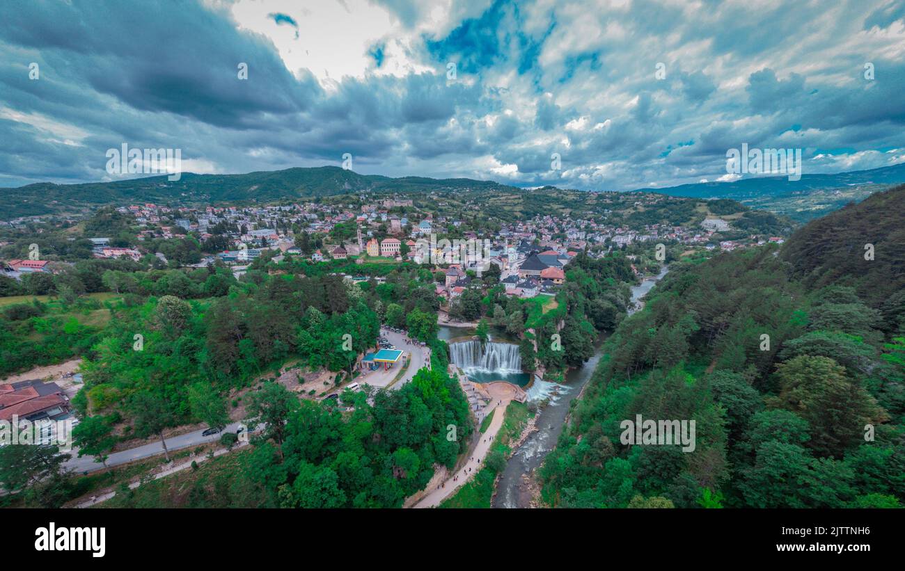 Pliva river waterfall and panorama of Jajce city in western Bosnia. Drone perspective or aerial photo of Jajce in a cloudy day. Stock Photo