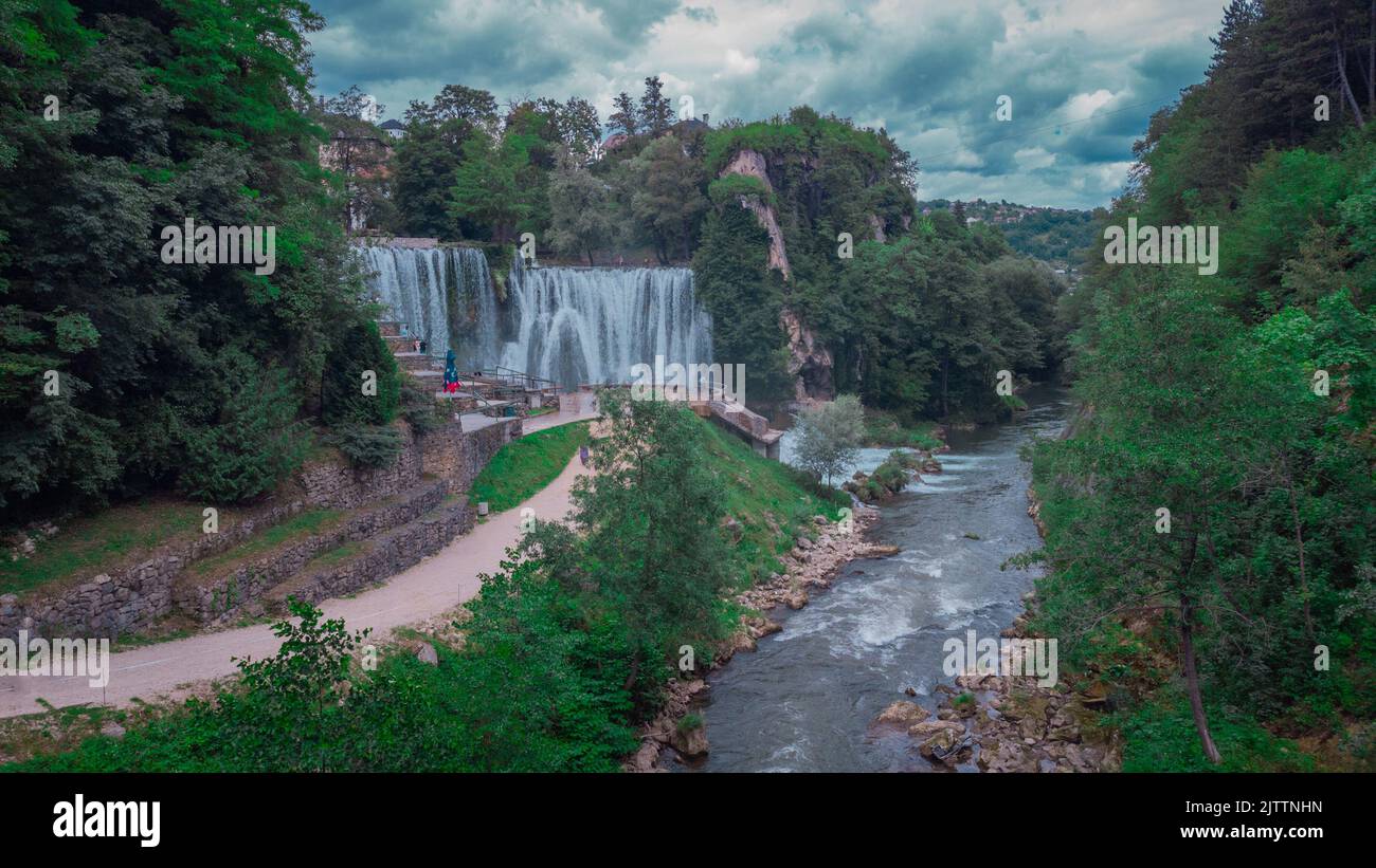 Aerial drone panorama of Pliva river waterfalls at Jajce, bosnia and hercegovina. Spectators looking at the waterfalls on a cloudy day. Stock Photo