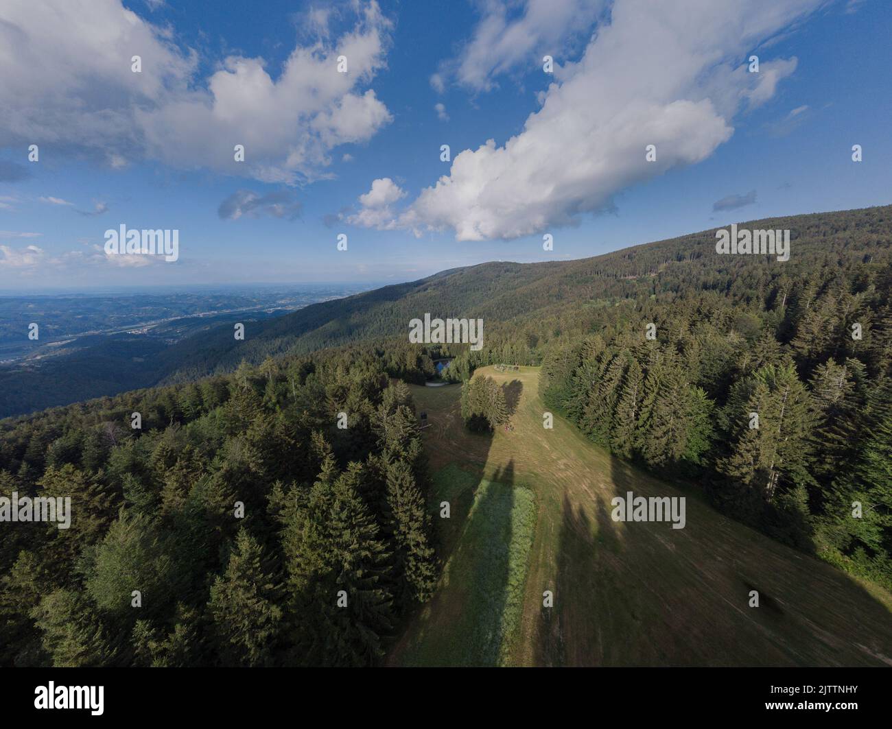 Aerial view of Ruse and looking towards the city of maribor just over the Pohorje hills with thick and dense forest.Drone panorama of drava valley fro Stock Photo
