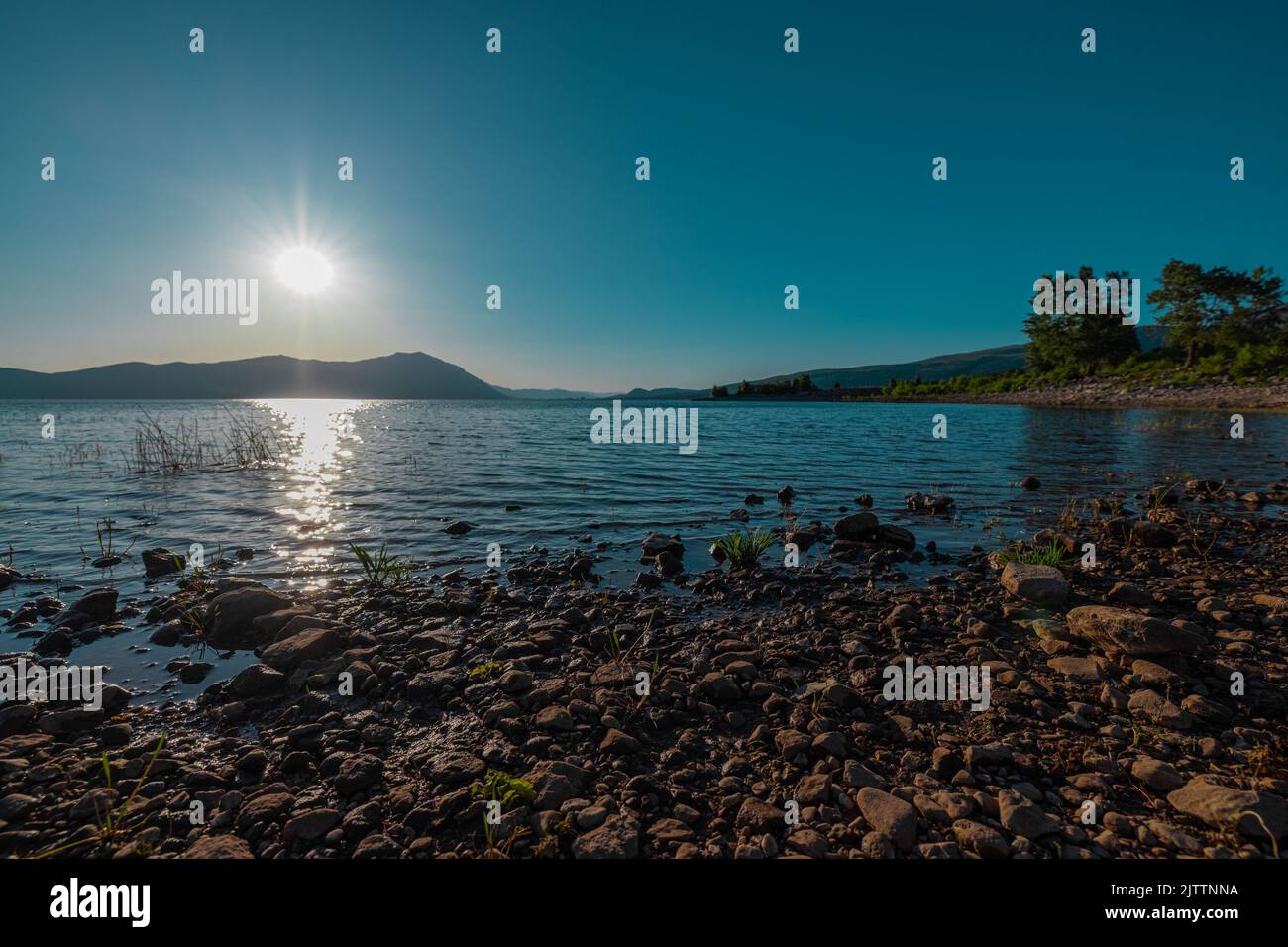 Busko jezero or lake in western bosnia, biggest lake in the region in early evening with the sun just about to set. Nice stones, rocks and water. Stock Photo