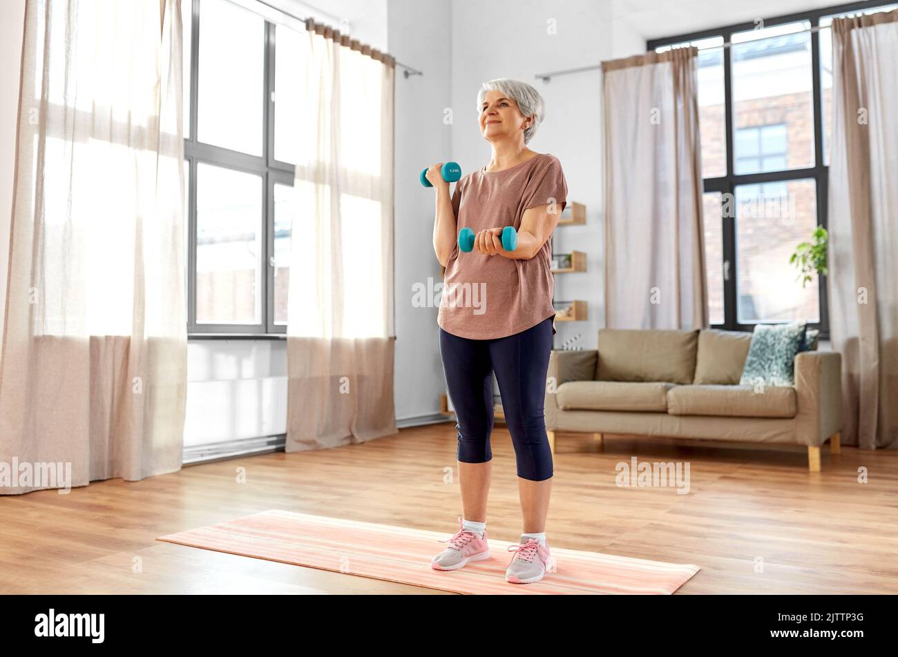 senior woman with dumbbells exercising at home Stock Photo - Alamy