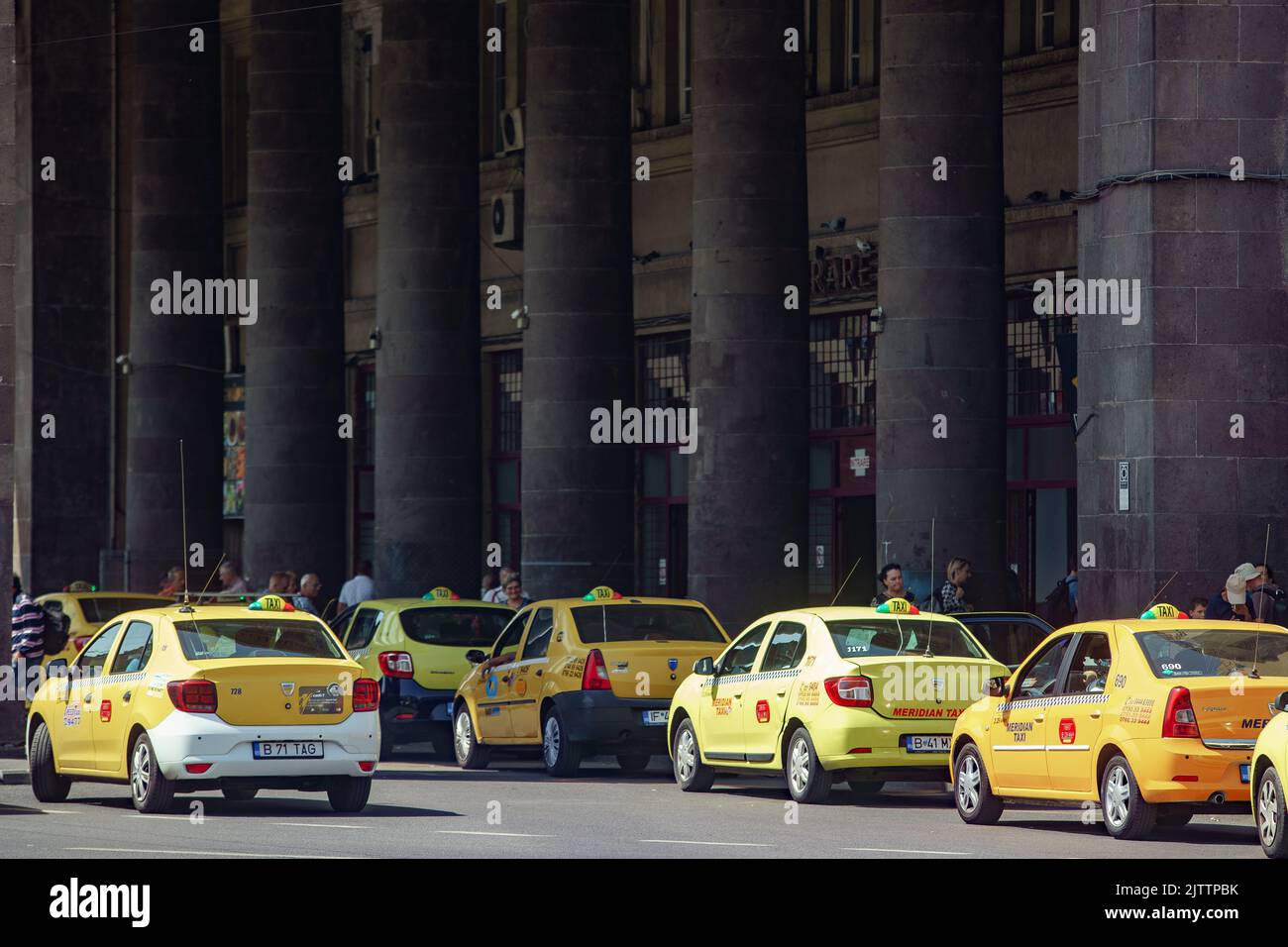 Bucharest, Romania - August 25, 2022: Yellow taxi cabs waiting in line for customers in front of the Northern Train Station in Bucharest This image is Stock Photo