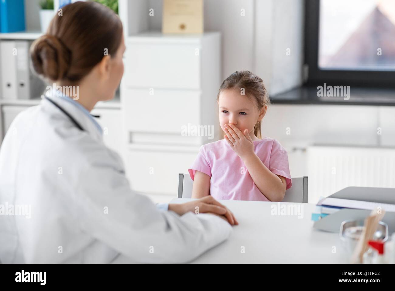doctor and little girl patient coughing at clinic Stock Photo Alamy