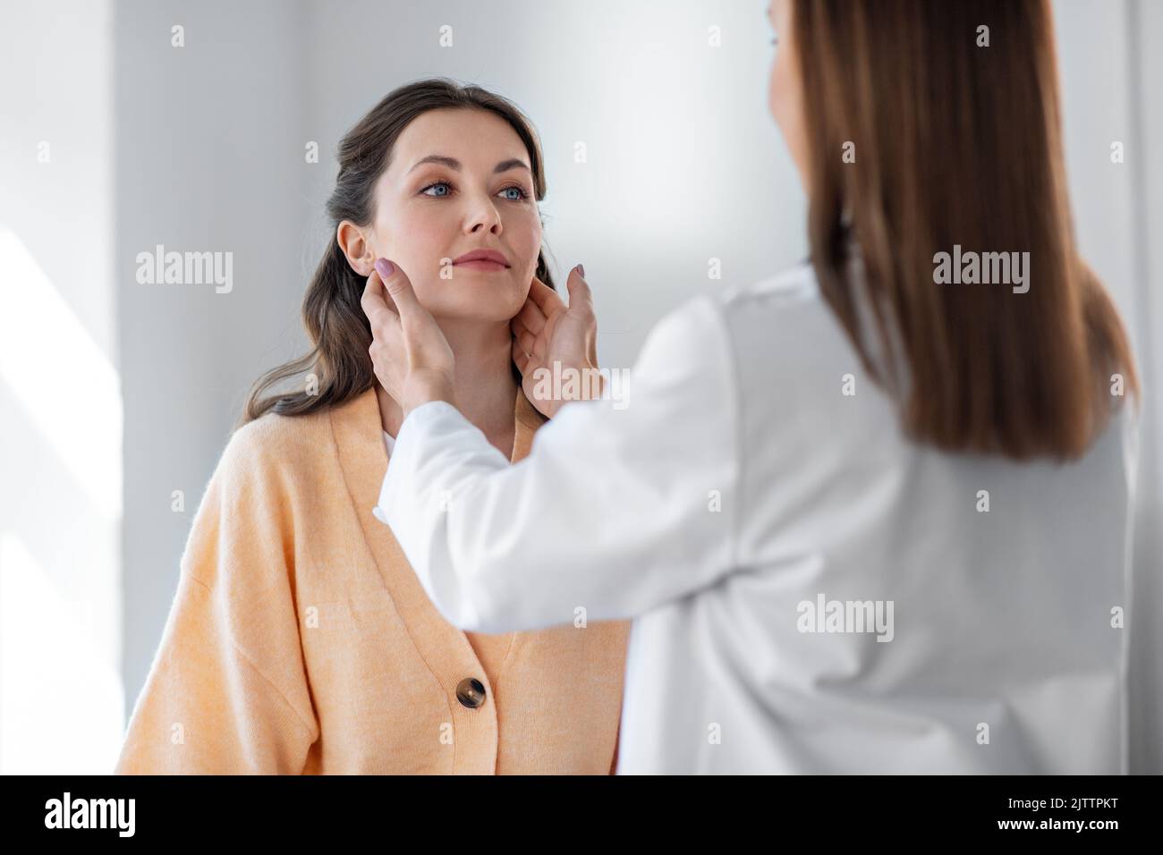 doctor checking lymph nodes of woman at hospital Stock Photo