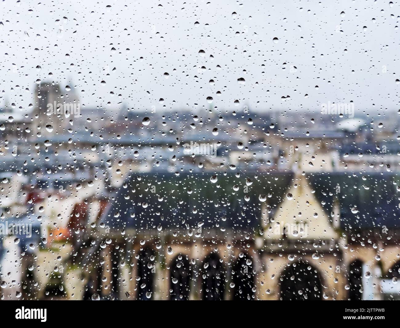 View through the wet window glass on roofs of Paris buildings Stock Photo