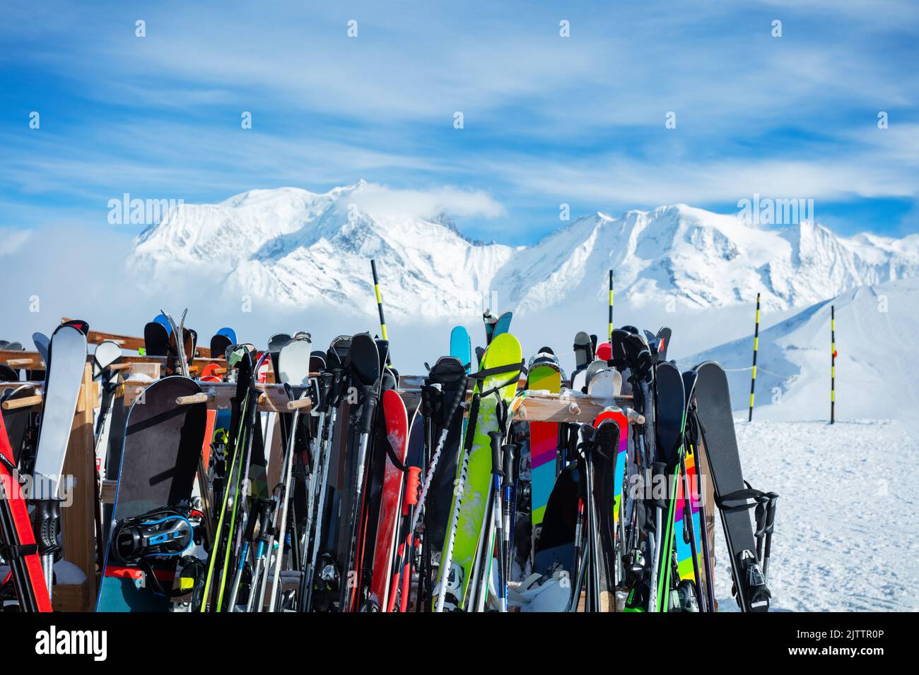 Many skis stand on alpine resort over mountain tops Stock Photo