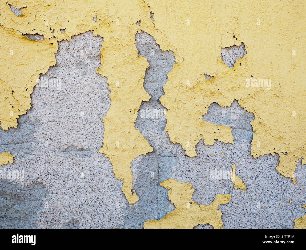 Peeling yellow paint on concrete wall texture Stock Photo