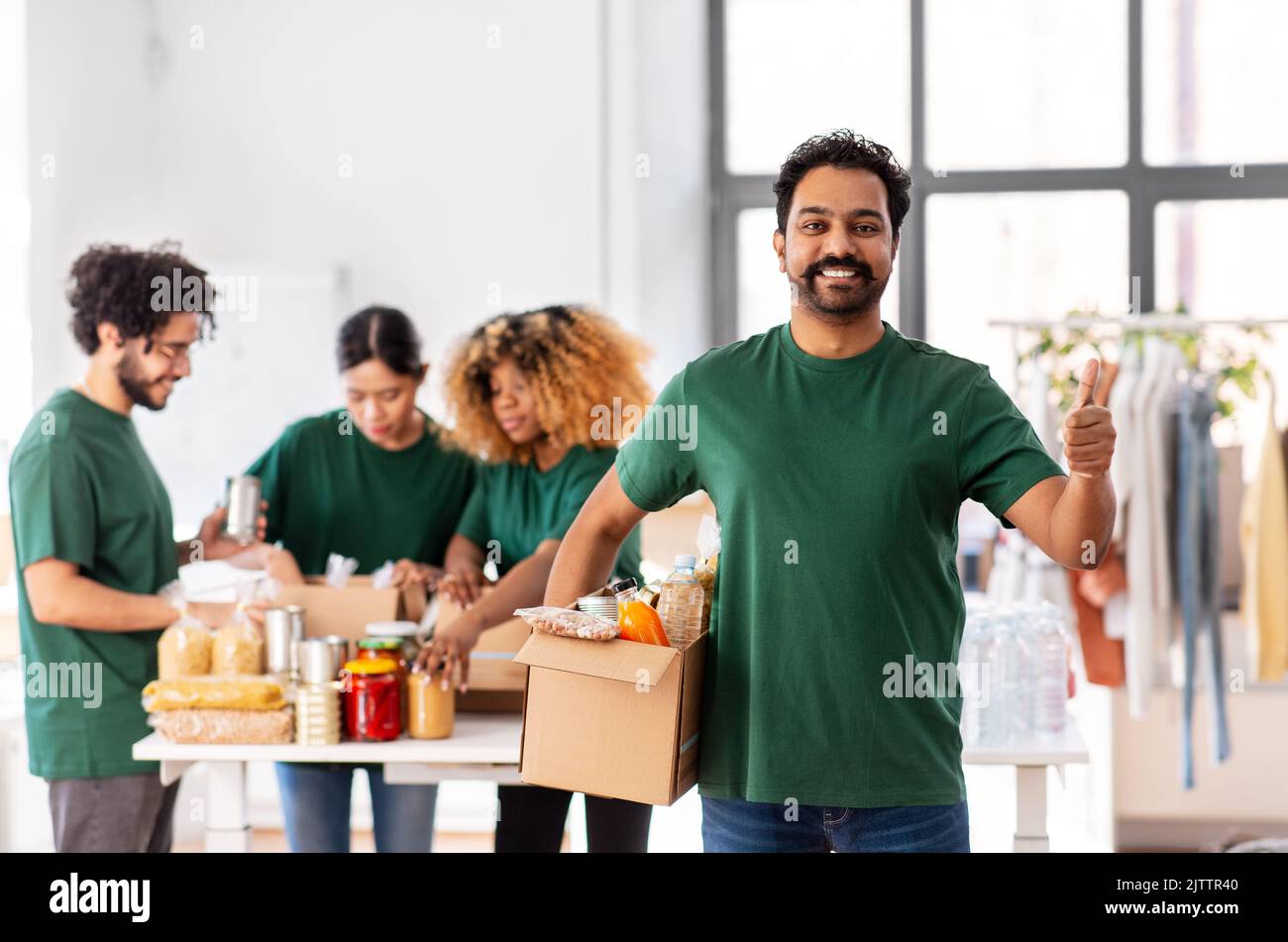 male volunteer with food in box showing thumbs up Stock Photo - Alamy