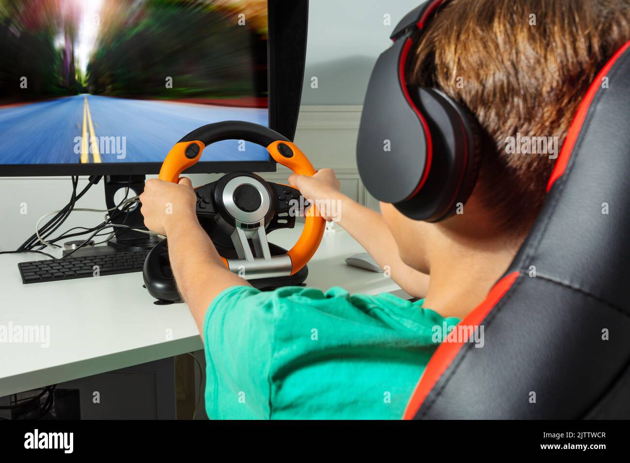 Close-up of boy's hands on steering wheel play race game Stock Photo