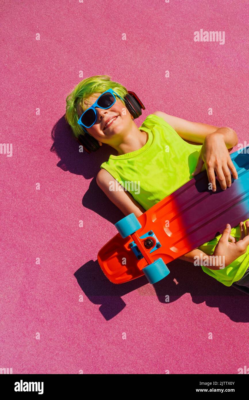 Handsome boy from above with green hair hold skateboard Stock Photo