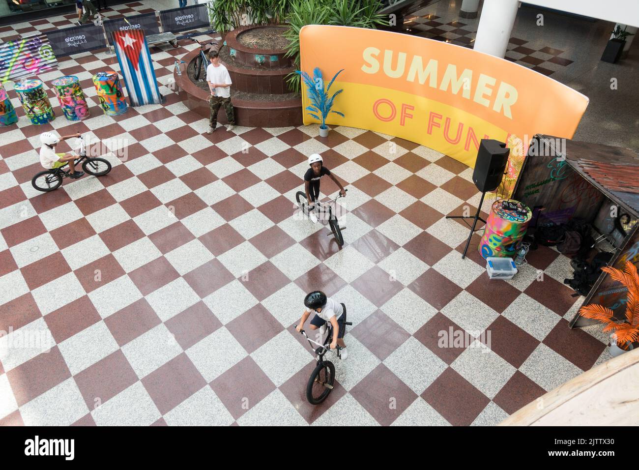 Top down view of Kids learning BMX bikes indoor in a shopping center Stock Photo