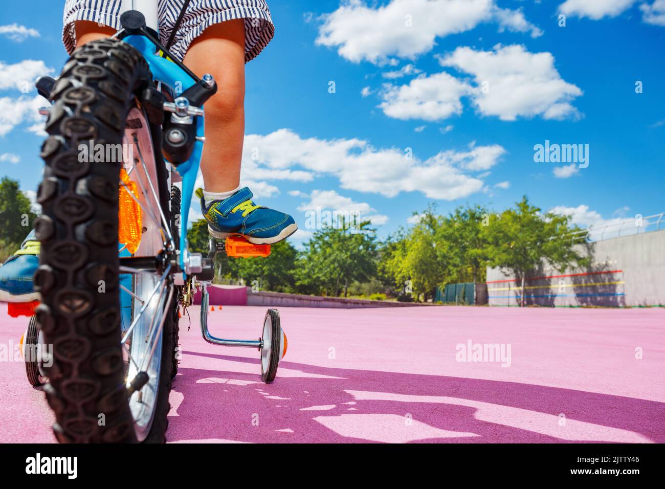 Low angle photo of the little bicycle wheel and boy push pedals Stock Photo