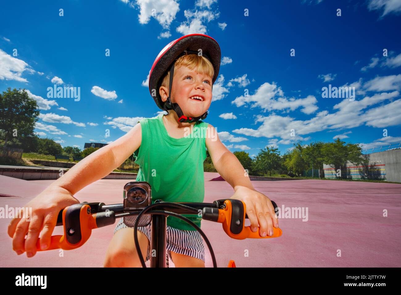 Boy on little bicycle in helmet riding at park portrait Stock Photo