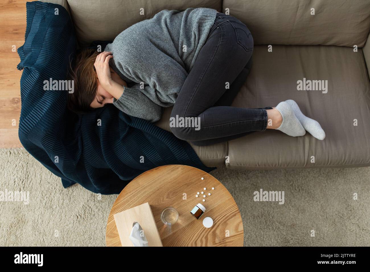 depressed woman lying on sofa at home Stock Photo