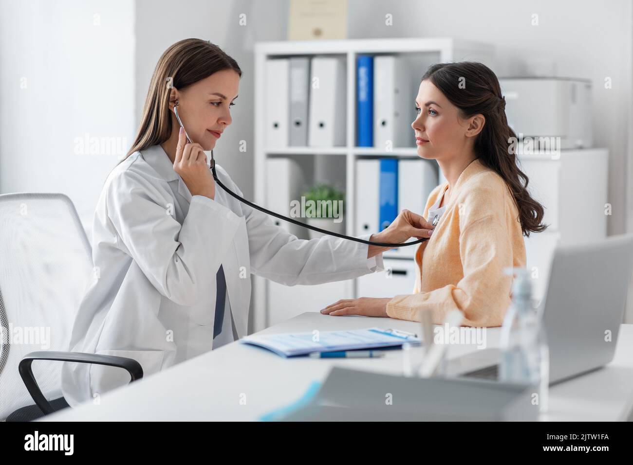 doctor with stethoscope and woman at hospital Stock Photo