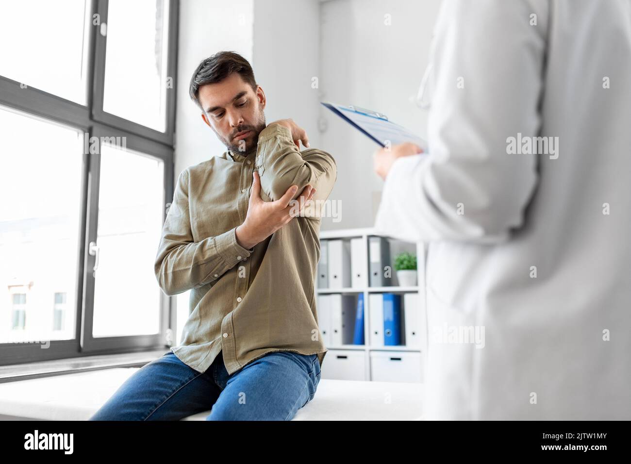 man patient showing sore arm to doctor at hospital Stock Photo Alamy