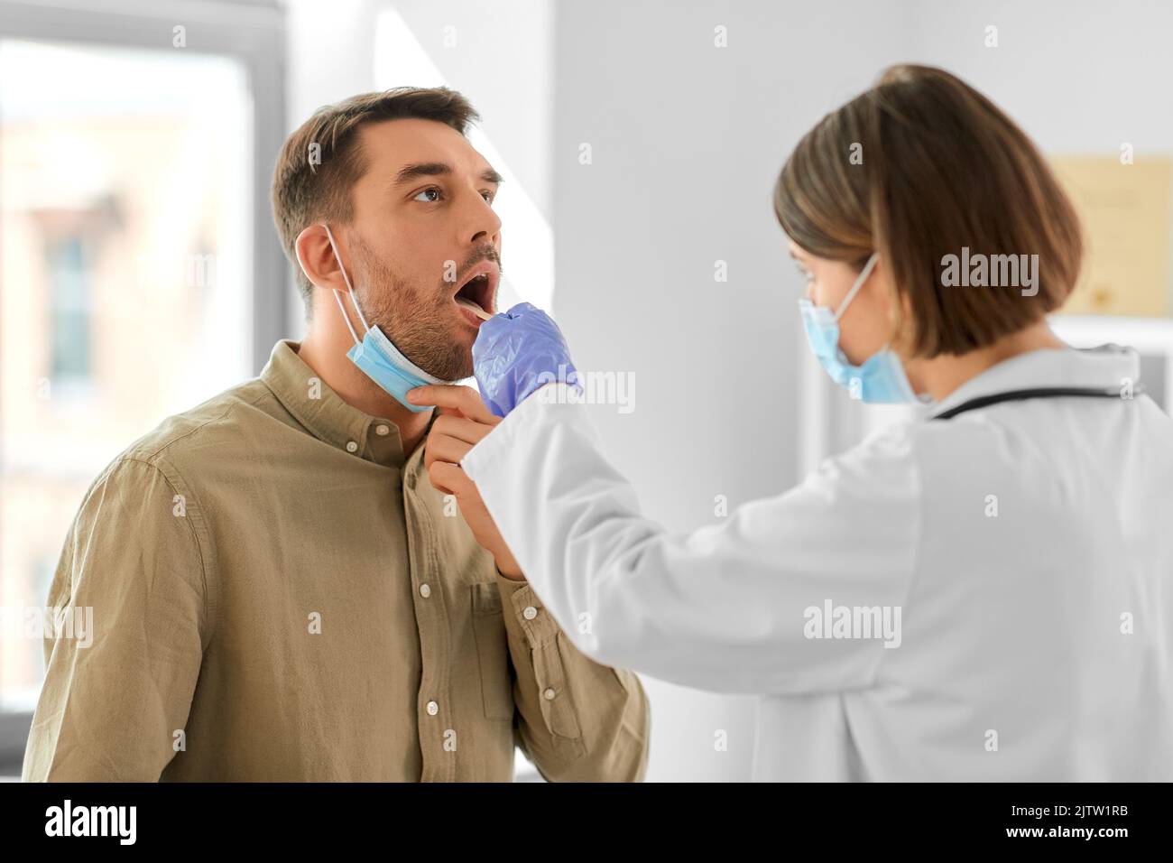 doctor checking male patient's throat at hospital Stock Photo Alamy